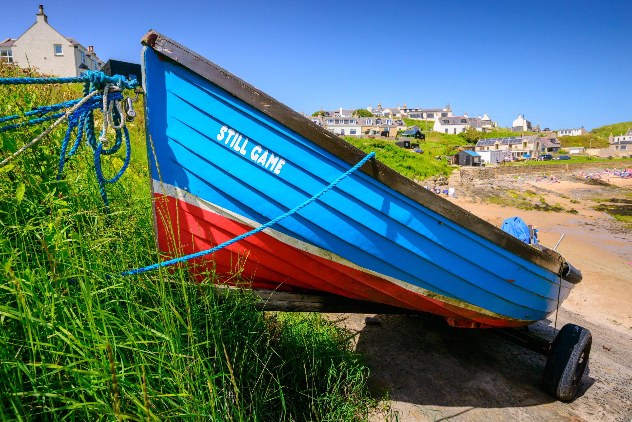 A brightly painted fishing boat beside Collieston Bay